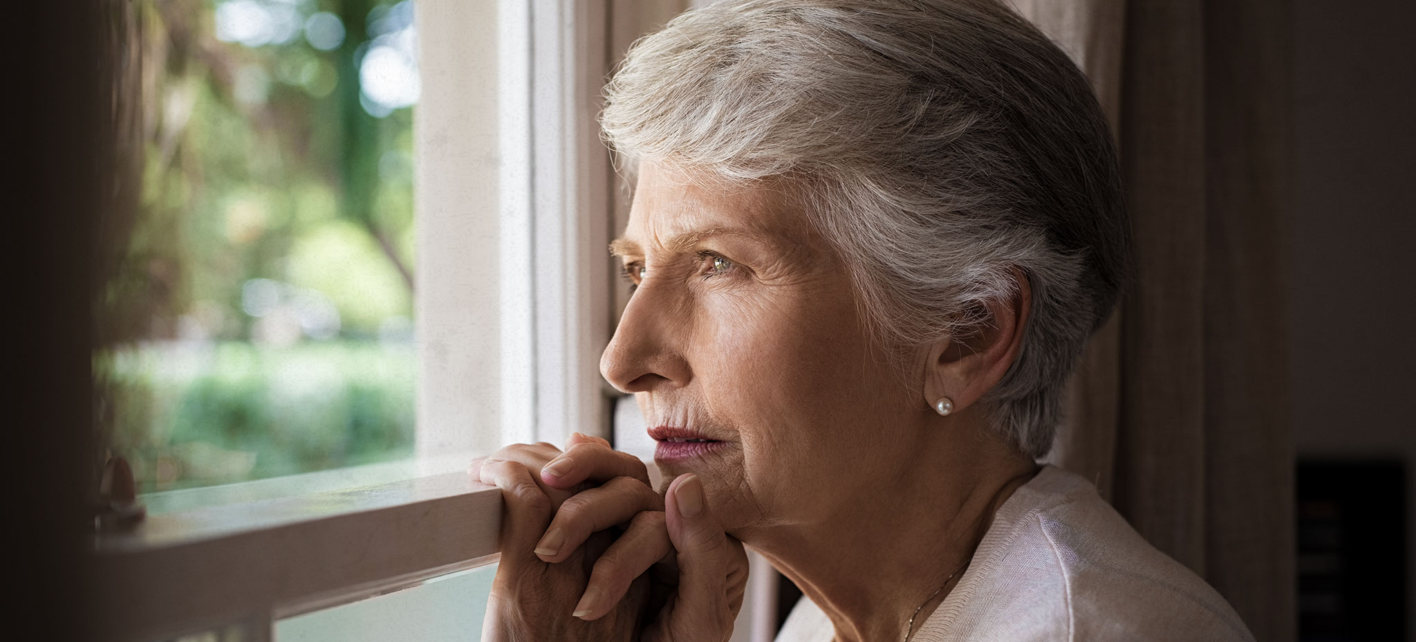 Older-woman-looking-out-window - Rheinhardt & Bray